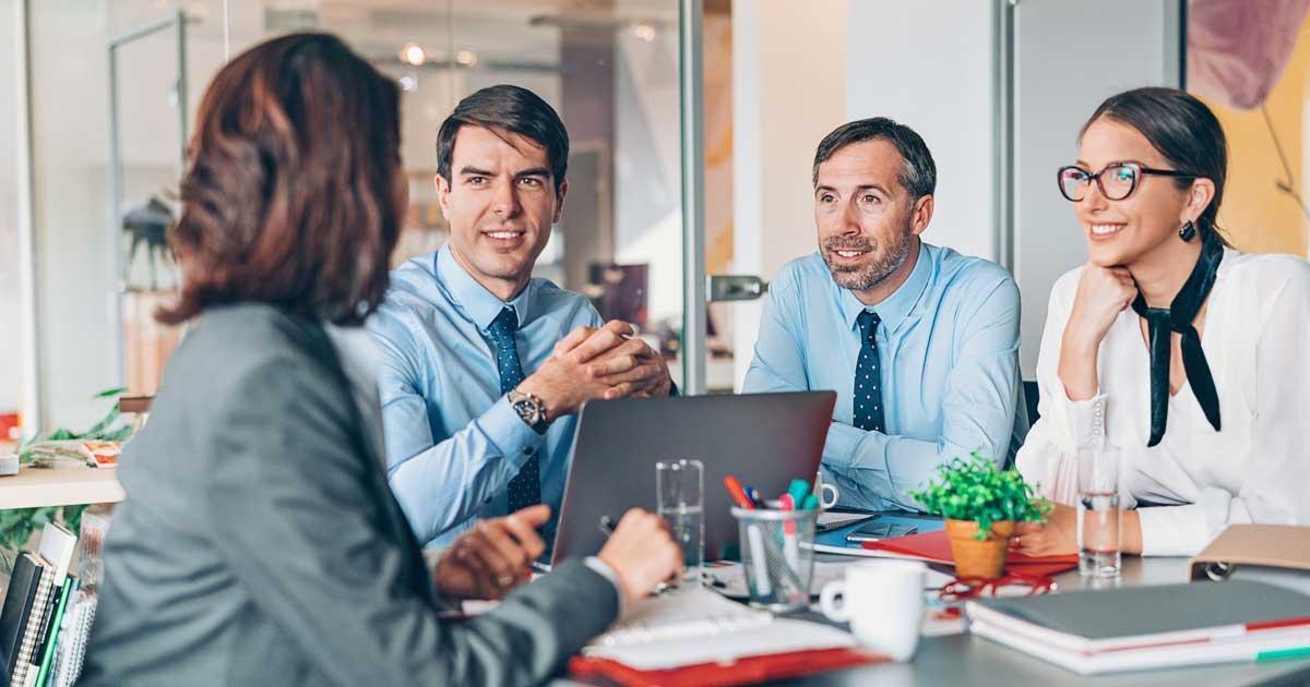 Business leaders share ideas around a table.